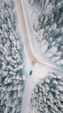 The Car is Driving on A road Covered in Snow