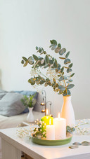Burning Candles and Eucalyptus in Vase in White Bedroom