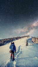 A Photographer Walks in The Snow Under The Stars