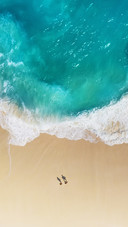Couple Walking on The Beach by The Sea