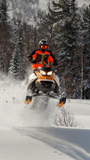 Man Riding A Snowmobile Speeding Through The Snow