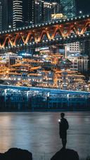 Man Standing by The River Under The Bridge at Night