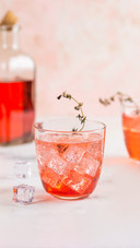 Alcoholic pink cocktail with ice and lime