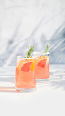 Two glasses with cold cocktail of grapefruit and ice