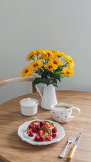 A bouquet of flowers on a round wooden table