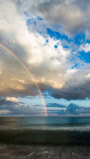 Rainbow spans the sky, beauty reflected