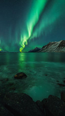 Glaciers and snowcapped peaks reflect the aurora