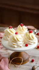 Homemade white mini desserts pavlova on wooden cake