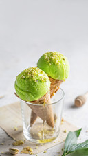 Two pistachio ice cream cones in a glass