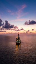 Tender Drilling Oil Rig in the Middle of the Ocean at Sunset