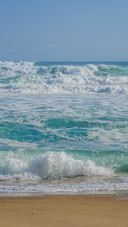 The waves crash against the beach