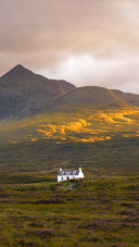 Traditional Scottish cottage with Cuillin mountain peaks