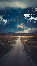 The Car is Driving on The Road at The Foot of The Mountain
