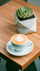 Delicious cup of cappuccino in wooden background