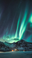 Northern Lights with Stars Glowing on Snowy Mountain