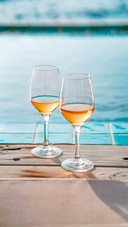 Two glasses of wine on the edge of infinity swimming pool