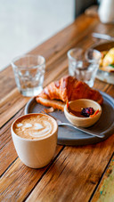 Top view of breakfast table with coffee and croissant