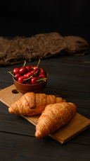 Croissants with Cherries on a Rustic Background
