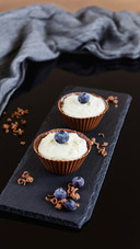 Chocolate tartlets with curd cream on a black table