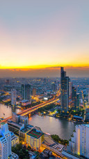 Bangkok's modern business buildings stand along the river