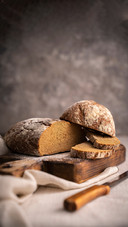 Sliced loaf of black bread on the wooden cutting board