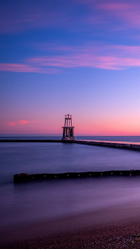 Lake Michigan water pours over walkway under morning sunrise