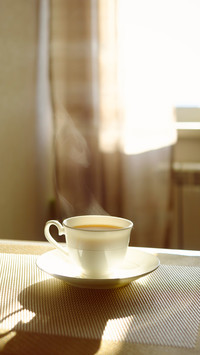a cup of hot steaming coffee on a sunny morning