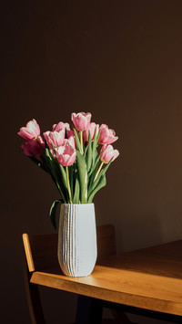 Gently pink bouquet of tulips in a vase on wooden table