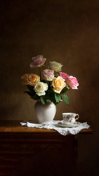 Still life with a beautiful bunch of roses and a cup of tea