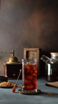 Glass of Iced Coffee on the Table Near the Wooden Window