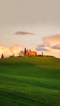 Amazing spring landscape with green rolling hills and farm
