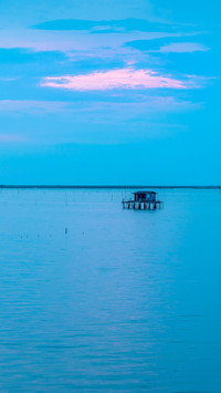 Beautiful twilight with fisherman house silhouette on sea