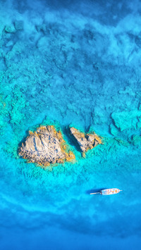 Beautiful yacht on the sea and rocks at sunset