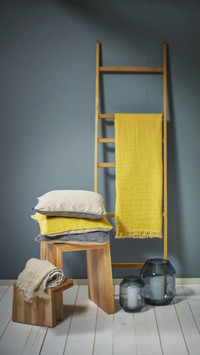 Yellow cloth draped over wooden ladder used as rack and