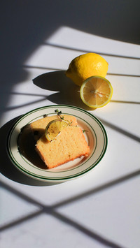 Homemade lemon cake on white, sunlit background