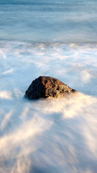 A beautiful view of sea waves crashing on beach rocks
