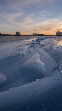 The frozen lake is still as a mirror's new surface.