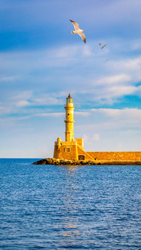 Lighthouse in old harbour of Chania with seagulls