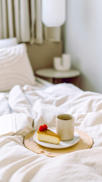Cake and drink on blanket in hotel room in morning