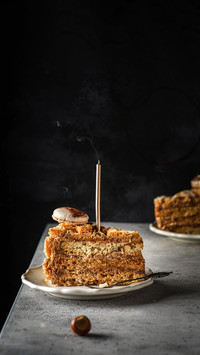 Meringue cake with hazelnuts and cream on a dark background