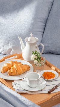 Breakfast in bed, a tray of coffee, french croissants