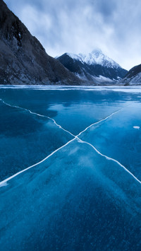 Cracked ice mirrors silent cold mountains