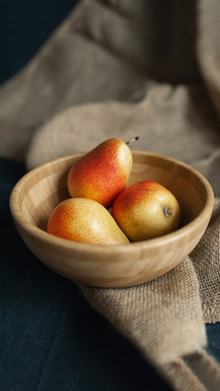 Ripe pears in a wooden plate