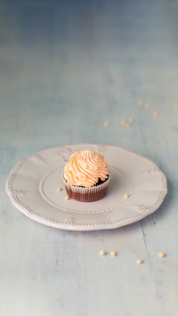 Chocolate cupcake with buttercream frosting on a white plate