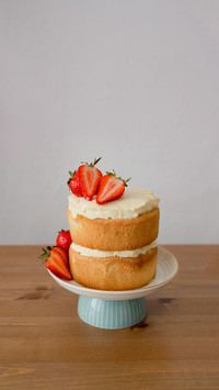 Strawberry cake on stand on wooden table