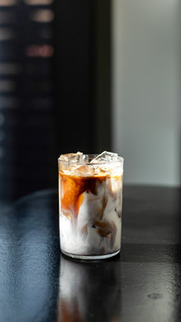 Iced coffee in glass on table in coffee shop blur background