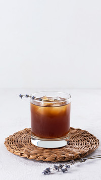 Cold drink with lavender in a glass on a light background