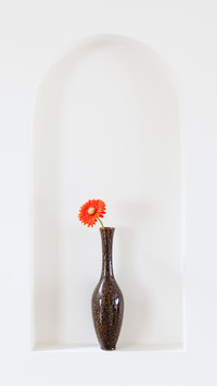 Vase with a red flower on a wall alcove