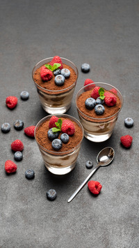 Tiramisu dessert with blueberries and raspberries in a glass