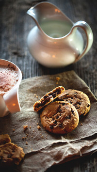 Chocolate chip cookies and cup of coffee on wooden table